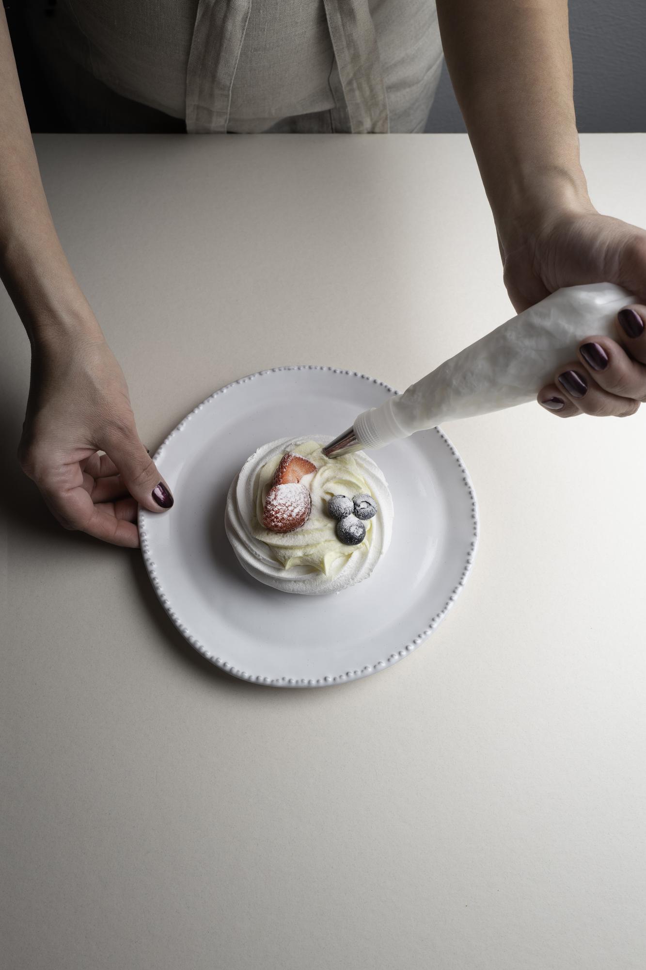 Studio chef plating a starter beside a small table